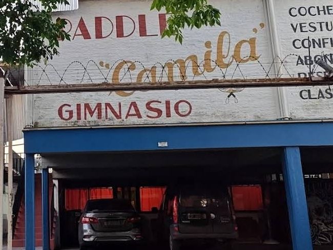Frente del club: cartel pintado «Paddle Camila · Gimnasio» sobre la cochera